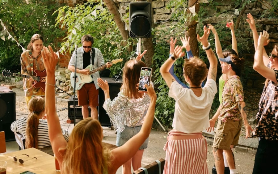 Idées de soirée d'entreprise : groupe en live et invités qui dansent lors d'un événement en plein air